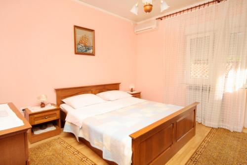 a bedroom with a large bed and a window at Apartments with a parking space Selce, Crikvenica - 5495 in Selce