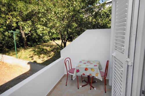 a table and two chairs on a balcony with a table at Apartments with a parking space Selce, Crikvenica - 5495 in Selce