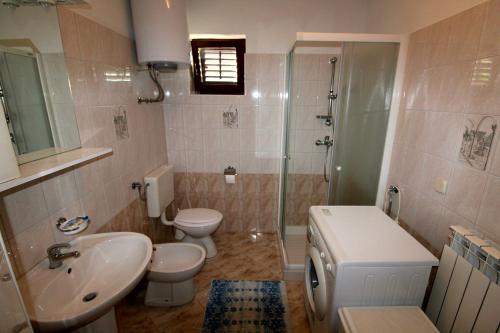 y baño con lavabo, aseo y ducha. en Family friendly apartments with a swimming pool Strmac, Labin - 5527, en Strmac