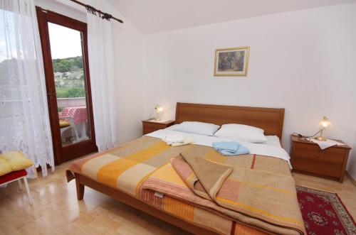 a bedroom with a bed and a large window at Apartments with a swimming pool Baska, Krk - 5354 in Baška