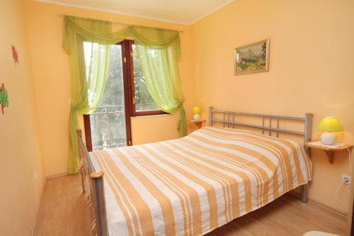 a bedroom with a bed and a window at Apartments by the sea Dramalj, Crikvenica - 5522 in Dramalj