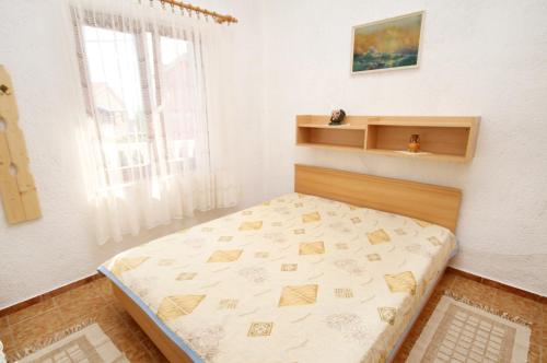 a bedroom with a bed in a room with a window at Apartments with a parking space Pinezici, Krk - 5319 in Pinezici