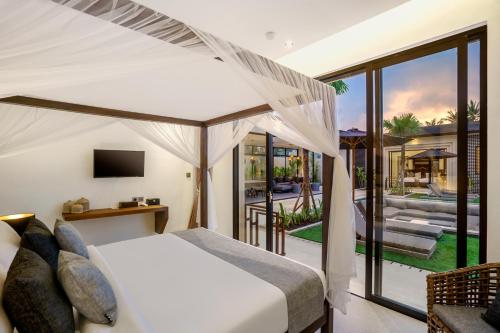 a bedroom with a bed and a view of a backyard at Villa Manga by BaliSuperHost in Ubud