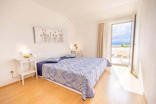 sypialnia z łóżkiem i widokiem na ocean w obiekcie Apartments with a parking space Njivice, Krk - 5427 w mieście Nijvice