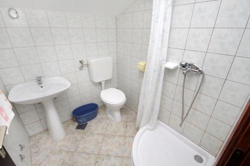 a bathroom with a toilet and a sink and a shower at Apartments with parking space Njivice, Krk - 5427 in Njivice