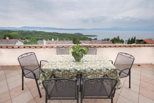 a table with chairs and a vase on a balcony at Apartments with parking space Njivice, Krk - 5427 in Njivice