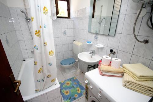 uma casa de banho com um lavatório, um WC e um chuveiro em Apartments by the sea Krk - 5400 em Krk