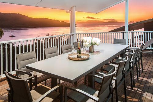 a table and chairs on a balcony with a view of the ocean at Casuarina Cove on Hamilton Island by HIHA in Hamilton Island