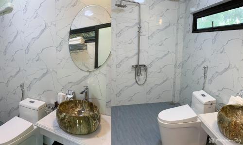 a bathroom with a toilet and a sink and a mirror at Mai Chau Sky Resort in Mai Chau