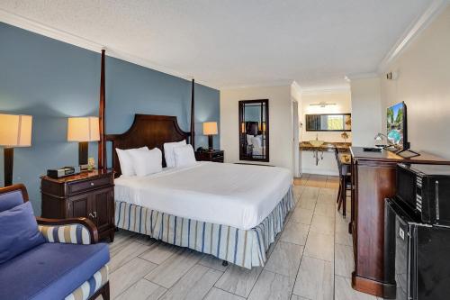 Fort Lauderdale Grand Hotel في فورت لاودردال: غرفة الفندق بسرير كبير ومكتب