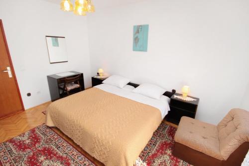 - une chambre avec un lit et une chaise dans l'établissement Apartments with a parking space Krk - 5321, à Krk