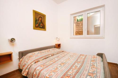 a bedroom with a bed and a window at Apartment Njivice 5398h in Njivice