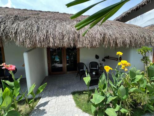 a house with a thatch roof and a patio at Secret paradise moalboal in Moalboal
