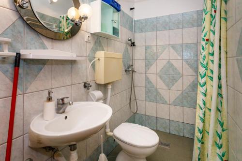 a bathroom with a sink and a toilet and a mirror at Apartments with a parking space Kornic, Krk - 5306 in Kornić