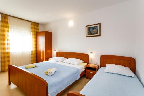 a hotel room with two beds and a window at Apartments with a parking space Kornic, Krk - 5306 in Kornić