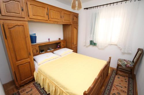 1 dormitorio con 1 cama y armario de madera en Apartments by the sea Businci, Ciovo - 5256 en Trogir