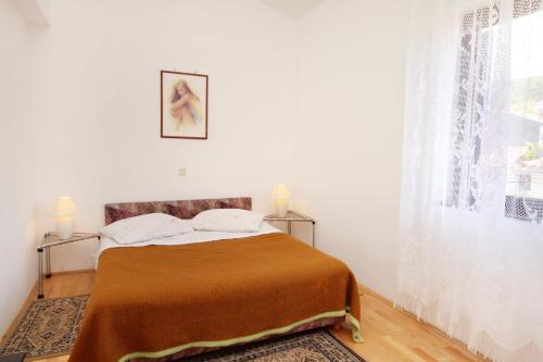 a bedroom with a bed and a window at Apartments by the sea Punat, Krk - 5328 in Punat