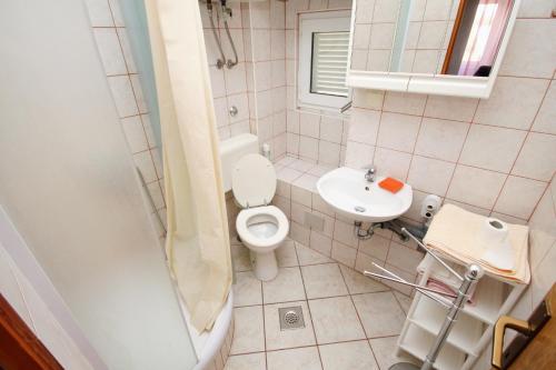Apartments by the sea Punat, Krk - 5329 في بونات: حمام صغير مع مرحاض ومغسلة