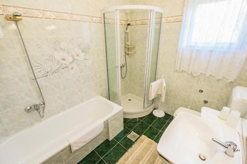 a bathroom with a tub and a shower and a sink at Apartments with a parking space Smrika, Kraljevica - 5508 in Šmrika