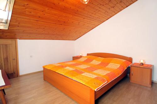 a bedroom with a bed and a wooden ceiling at Apartments with a parking space Punat, Krk - 5428 in Punat