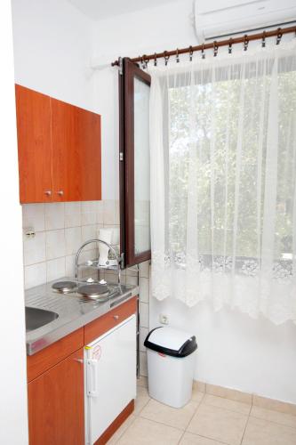 a small kitchen with a sink and a window at Apartments with parking space Punat, Krk - 5428 in Punat