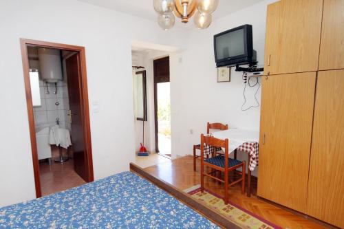 a room with a bed and a tv and a table at Apartments with a parking space Punat, Krk - 5428 in Punat