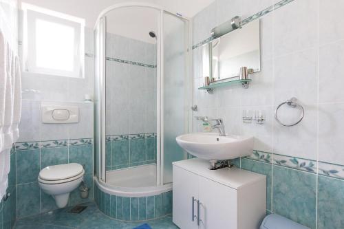 Apartment Punat 5408a في بونات: حمام مع مرحاض ومغسلة ودش