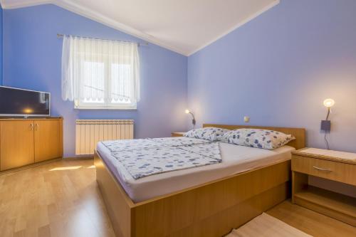 a bedroom with a large bed and a tv at Apartments by the sea Selce, Crikvenica - 5367 in Selce