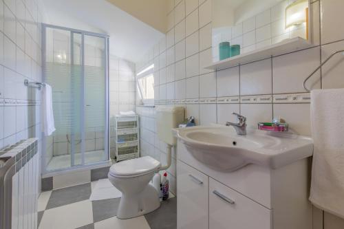 a white bathroom with a sink and a toilet at Apartments by the sea Selce, Crikvenica - 5367 in Selce