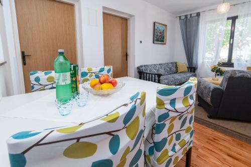 Apartment Punat 5351a في بونات: غرفة طعام مع طاولة مع وعاء من الفواكه