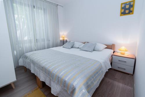 a bedroom with a large bed and a window at Apartments by the sea Punat, Krk - 5351 in Punat