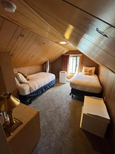 a attic room with two beds and a table at June Lake Villager in June Lake
