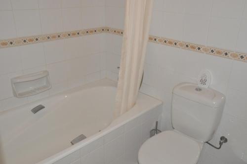 y baño blanco con aseo y bañera. en Tala Hills, en Pafos