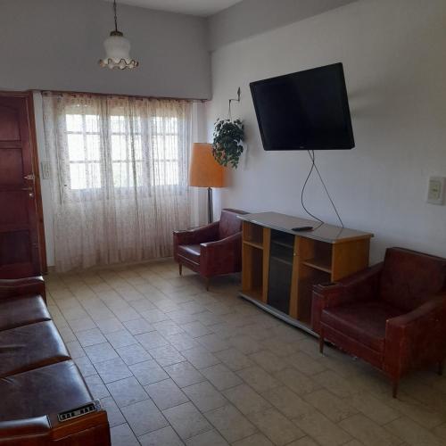uma sala de estar com sofás e uma televisão de ecrã plano em Casa sur FARO em Mar del Plata