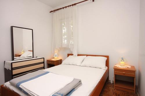 a small bedroom with a bed and a mirror at Apartments with a parking space Punat, Krk - 5350 in Punat