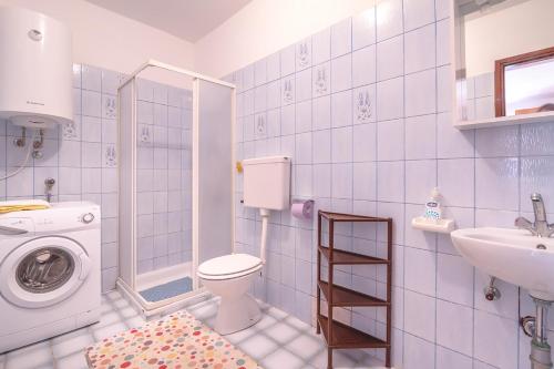 a bathroom with a toilet and a sink and a washing machine at Apartments and rooms with WiFi Njivice, Krk - 5362 in Njivice