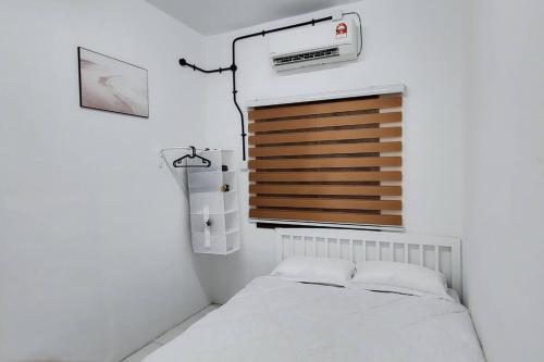 Cette chambre blanche dispose d'un lit et d'une fenêtre. dans l'établissement The Homestay 105 - nearby sky mirror jetty - Netflix & xbox, à Kuala Selangor