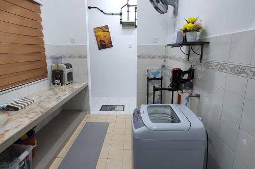 eine Waschmaschine im Bad mit einer Theke in der Unterkunft The Homestay 105 - nearby sky mirror jetty - Netflix & xbox in Kuala Selangor