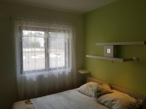 Habitación pequeña con cama y ventana en Apartments and rooms with parking space Punat, Krk - 5363, en Punat