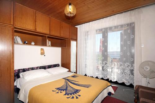 a bedroom with a bed with a yellow blanket and a window at Apartments with parking space Dramalj, Crikvenica - 5491 in Dramalj