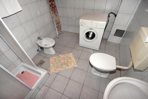 a bathroom with a toilet sink and a washing machine at Apartments with parking space Dramalj, Crikvenica - 5491 in Dramalj