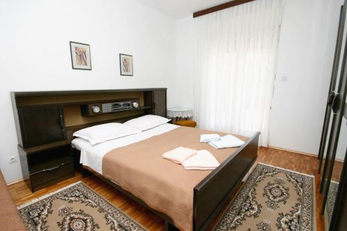 a bedroom with a large bed with two towels on it at Apartments with a parking space Selce, Crikvenica - 5513 in Selce