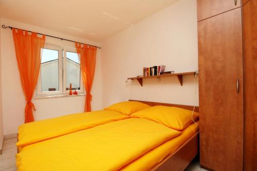 sypialnia z żółtym łóżkiem i oknem w obiekcie Apartment Pinezici 5464c w mieście Pinezići