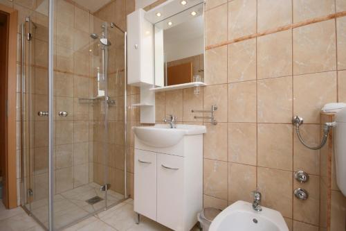 a bathroom with a sink and a shower and a toilet at Apartment Pinezici 5464c in Pinezici