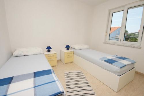 a bedroom with two beds and a window at Apartment Pinezici 5464b in Pinezici