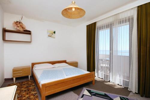 a bedroom with a bed and a large window at Apartments and rooms with parking space Stara Baska, Krk - 5447 in Stara Baška