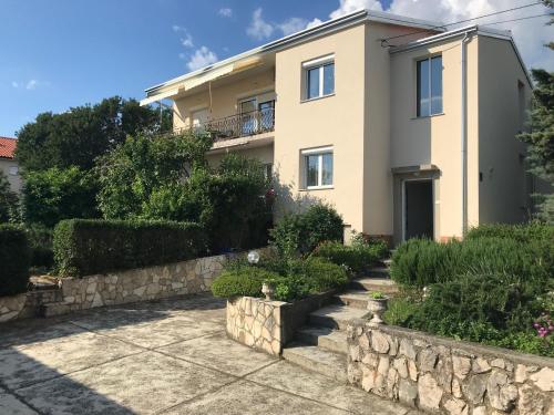 a house with a stone wall in front of it at Apartments with a parking space Smrika, Kraljevica - 5338 in Šmrika