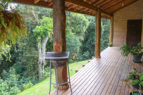 a wooden deck with a grill on it at Refúgio Mantiqueira - Parte Alta Parque Nacional Itatiaia in Itamonte