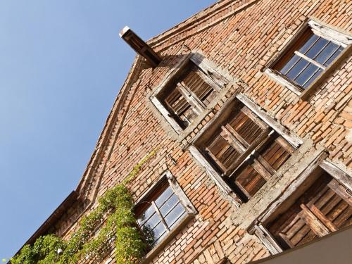 a brick building with a cross on top of it at Hotel Restaurant Grüner Baum und Altes Tor in Bad Waldsee