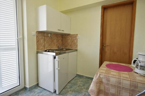eine kleine Küche mit Spüle und Kühlschrank in der Unterkunft Apartment Novi Vinodolski 5526b in Novi Vinodolski